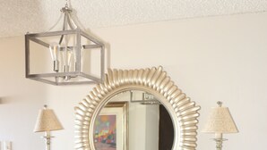 A console table with a decorative mirror, two lamps, and a small decorative item. - Beach Front (Rincón)
