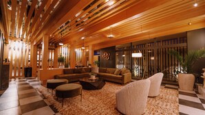 A spacious living area with a checkered floor, a sectional sofa, a coffee table, and a large rug. - Azure Sky Hotel - Adults Only - A Town & Desert Boutique Hotel (Palm Springs)