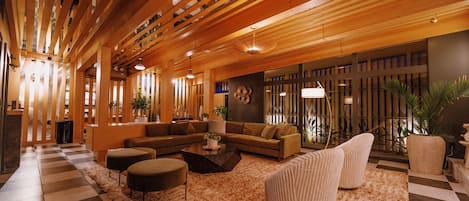 A spacious living area with a checkered floor, a sectional sofa, a coffee table, and a large rug.