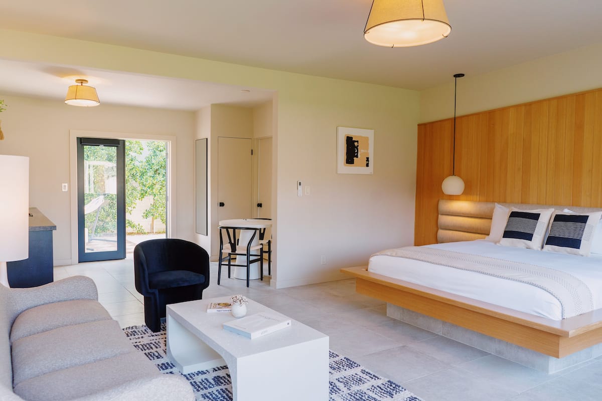 Un dormitorio moderno con una cama grande, un escritorio y una silla.
