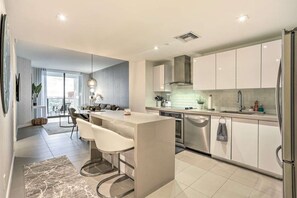 Enjoy cooking in this well-equipped kitchen with a central island and bar stools, featuring an oven and dishwasher.
