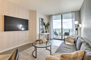 Relax in this stylish living room with a flat-screen TV, comfortable sofa, and city views.