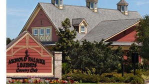 A building with a red facade, multiple dormer windows, and a sign reading "Arnold Valley Lodge Country Club".