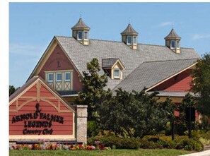 Arnold Palmer Country Club's charming clubhouse features a traditional design with a central gable and dormer windows.