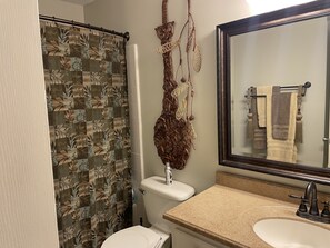 Een bad/douchecombinatie, een haardroger, handdoeken, toiletpapier