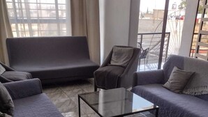 Un salon moderne avec un canapé, des fauteuils et une table basse.