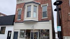 Un edificio en esquina con escaparate que muestra 'Lakeshore Trends' y un letrero de 'Estacionamiento por 3 horas'.
