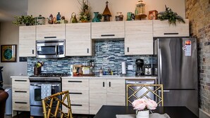 Una cocina moderna con armarios de madera, un refrigerador de acero inoxidable y un protector contra salpicaduras de azulejos.
