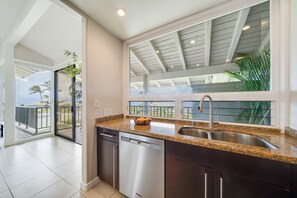 Enjoy cooking in this well-lit kitchen with a granite countertop, stainless steel sink, and dishwasher.