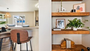 A modern kitchen with a central island, bar stools, and a hanging pendant light. - 🌞 Meridian BNB - 4BR/2.5BA Huge Backyard: Near Eagle, Star, Boise, The Village (Meridian)