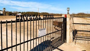 A gated area with a 'POSTED' sign, a lamp post, and a fence. - Quiet Crystal Creek Ranch Bunkhouse with large private pond (Brackettville)