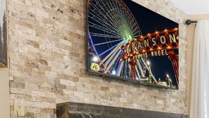 A brick fireplace with a mounted TV displaying a Ferris wheel. - Woodsy Wonder - Pools, Hot tub, Gated & Golf CENTRAL LOCATION (Branson)