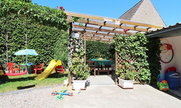 A children's play area with a slide, swings, and a climbing structure.