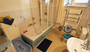 Un baño con bañera, ducha, inodoro y lavamanos.