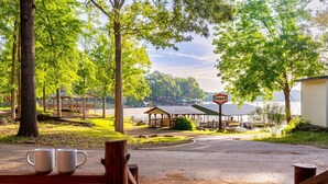 Un terrain de camping au bord du lac, équipé de tables de pique-nique, d’un kiosque et d’un panneau indiquant « TEXACO ».