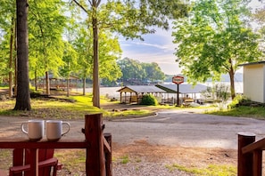 Un campeggio sul lago con tavoli da picnic, un gazebo e un cartello con scritto 'TEXACO'.