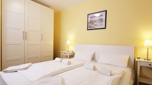 A hotel room with two beds, white linens, a painting on the wall, and bedside lamps. - Meeresblick - Welcome to the vacation apartment Meeresblick in Kühlungsborn (Kühlungsborn)