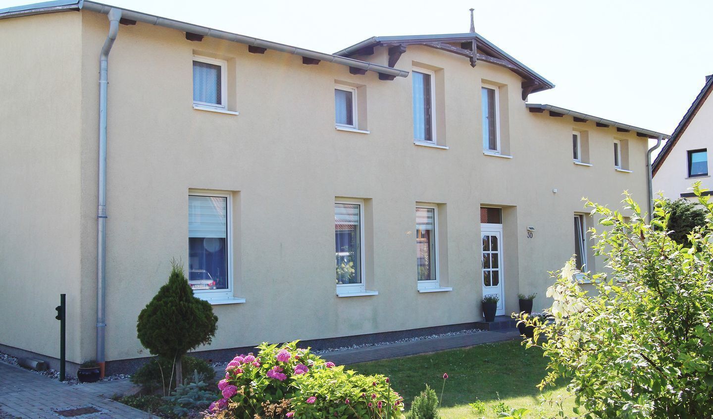Un bâtiment à deux étages, doté d’un toit plat et d’une façade symétrique.