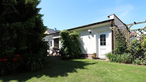 A house with a well-maintained lawn, a wooden fence, and a door with a window.