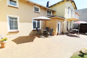 A patio area with outdoor furniture, a table, and chairs.