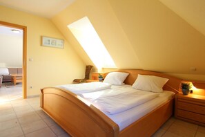 Una camera da letto con un letto grande, un comodino, una sedia e un tavolino.