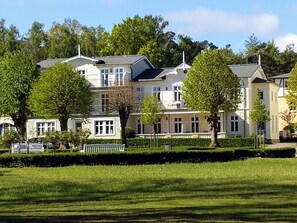 Une rangée d’immeubles résidentiels à plusieurs étages, avec une pelouse bien entretenue au premier plan.