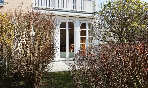 A building with a white facade, arched windows, and a balcony.