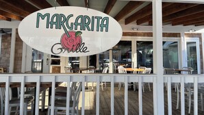 Une enseigne de restaurant avec l’inscription « Margarita Grille » et une illustration de rose.