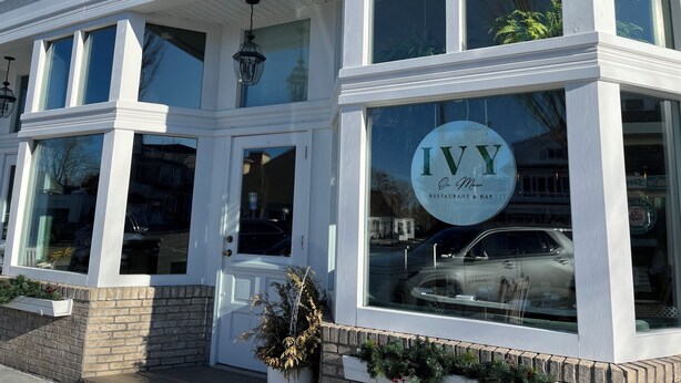 Un bâtiment à deux étages, dont la devanture est ornée d’une enseigne bien visible indiquant « Ivy Restaurant & Bar ».