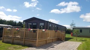 En træterrasse med et skilt der står 'Welsh Cottage'.