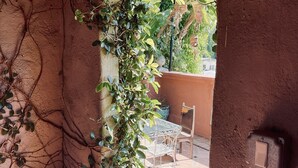 Una habitación rústica con pared de piedra, una planta en maceta y suelo de baldosas.