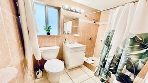 A bathroom with a toilet, sink, and shower area. - Beach Tide Motel - #6 Studio 1 King bed (Hollywood)