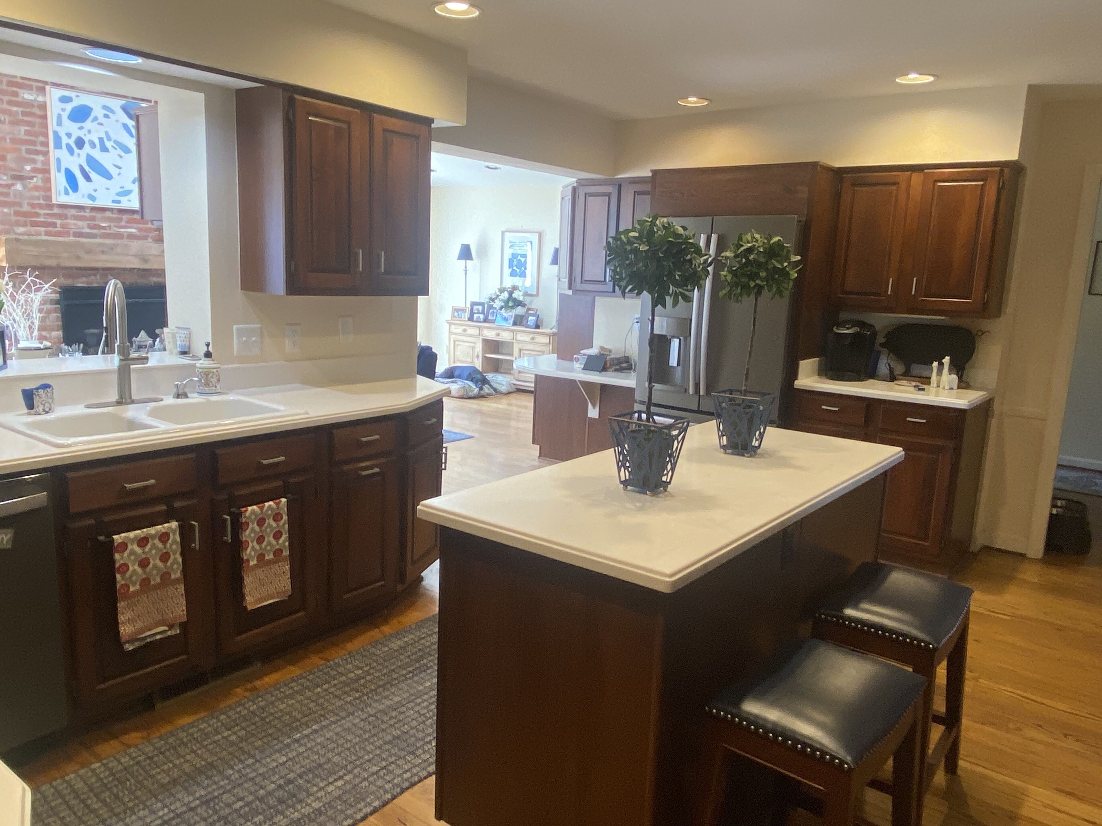 Una cocina con armarios de madera, una isla central y un refrigerador.