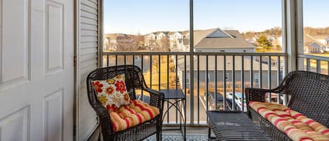 Enjoy the serene view from this balcony with two comfortable chairs and a small table.