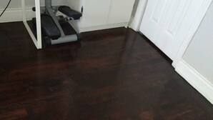 A room with a dark wooden floor, white cabinets, and a white door. - Warm apartment with a bus stop at its doorstep (Montreal)