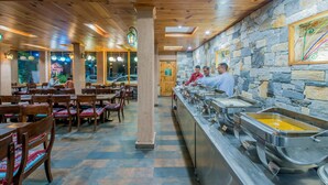Un restaurant amb sostres de fusta, parets de pedra i una barra tipus bufet.