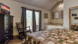 Ein Schlafzimmer mit Bett, Schminktisch, Stuhl, einem Fenster mit Vorhängen, einer Badewanne und Wanddekorationen.