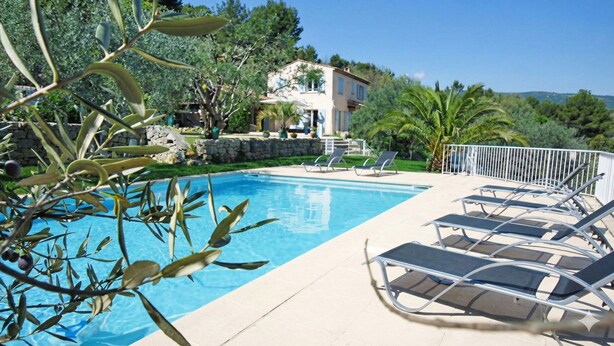 A swimming pool with lounge chairs and a stone wall. - Magnificent, peaceful villa surrounded by olive trees. Exceptional panoramic view (Fayence)