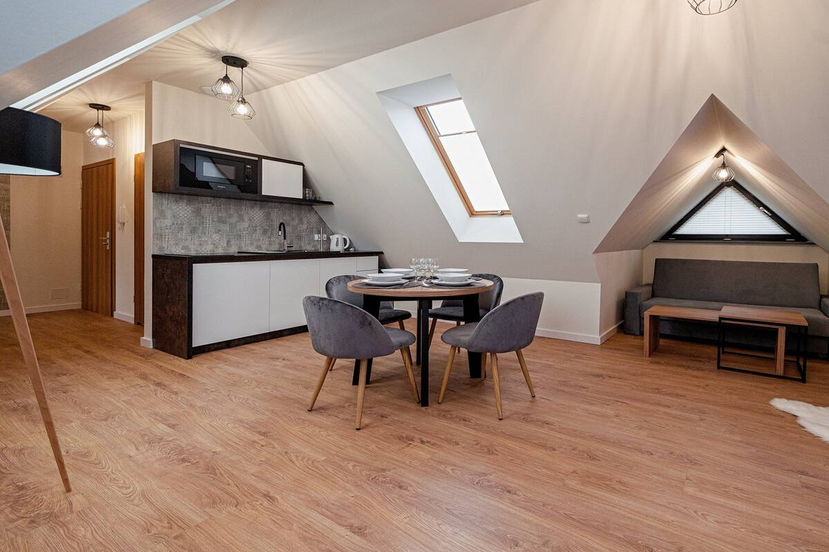 En moderne loftlejlighed med spiseplads, køkken og siddeområde.