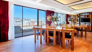 A spacious dining area with a large table and chairs, a bookshelf, and a television. - Cagliari Upper House (Cagliari)