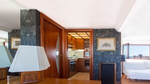 A modern kitchen with wooden cabinets, a marble backsplash, and a dining area with a wooden table and chairs. - Cagliari Upper House (Cagliari)