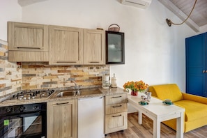 A kitchen with wooden cabinets, a gas stove, a sink, and a white countertop.