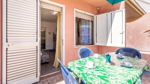 A room with a table set for two, a door, and a window with shutters.