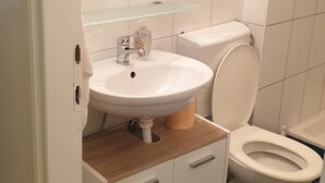 Ein Badezimmer mit Waschbecken, Toilette und Spiegel darüber.