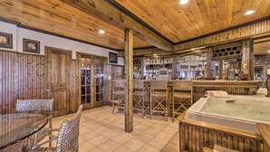 Un interior de madera con una zona de bar, sillas de mimbre y un jacuzzi.