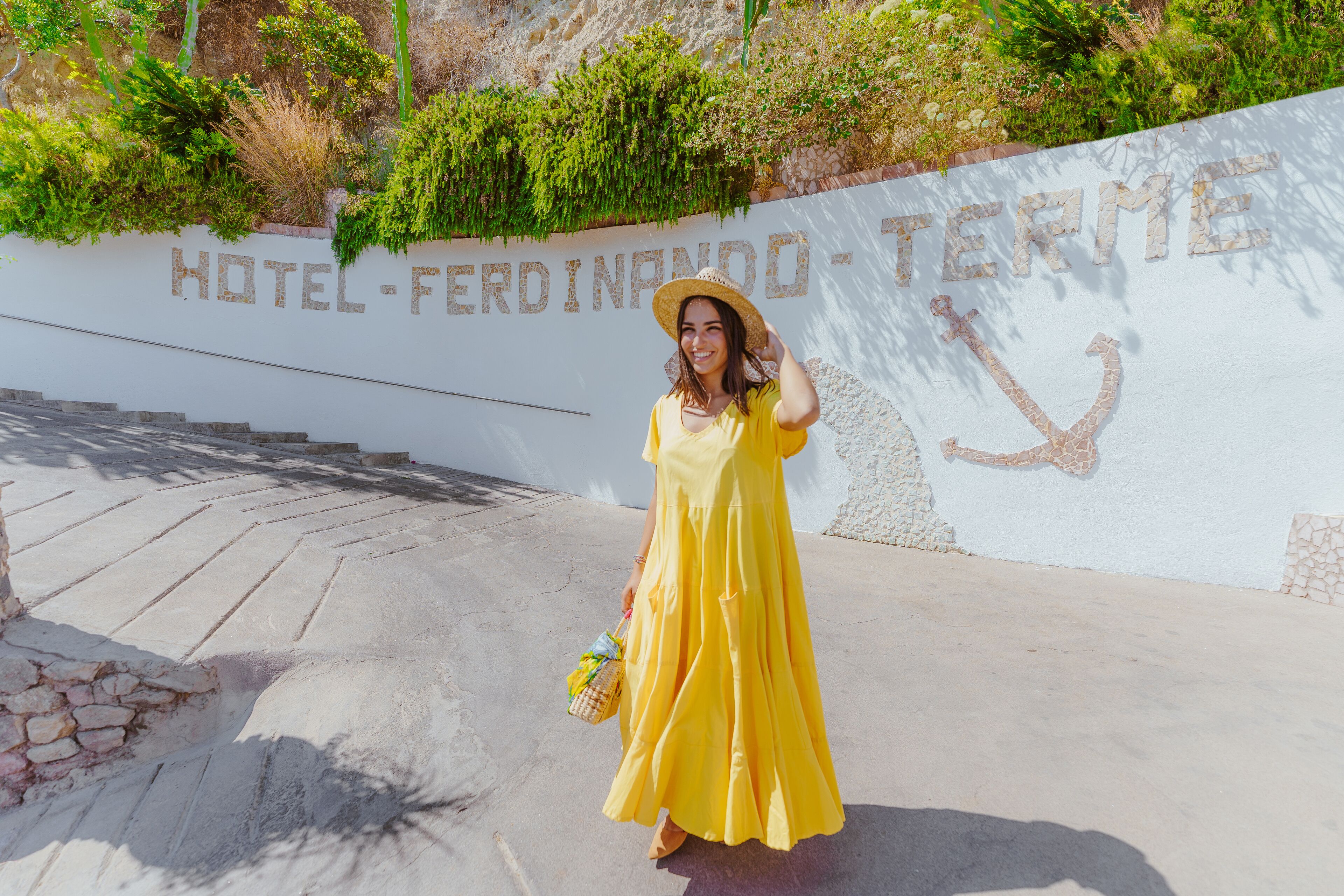 A person standing in front of a wall with the text "HOTEL FERNANDO TERME".