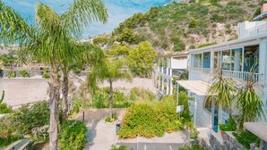 A coastal building with a balcony overlooking a garden and a hillside. - Ferdinando Beach & Spa (Serrara Fontana)