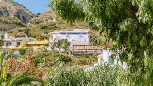 A hotel named 'HOTEL FERNANDO TERME' with a white facade, balconies, and a garden area with pink flowers. - Ferdinando Beach & Spa (Serrara Fontana)
