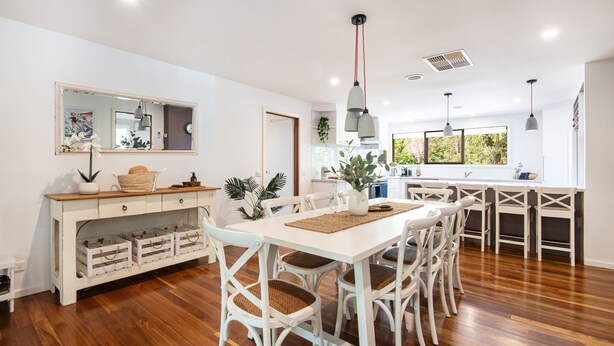 A modern kitchen with white cabinetry, a dining area with white chairs, and a large window providing natural light. - Pet Friendly - Preston Alfresco Poolside Retreat Rye (Rye)