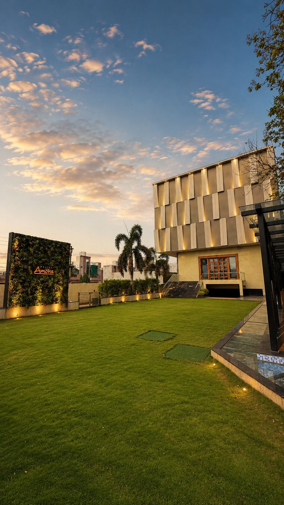 Un edificio moderno con techo plano, un césped bien cuidado y una escalera que conduce a la entrada.